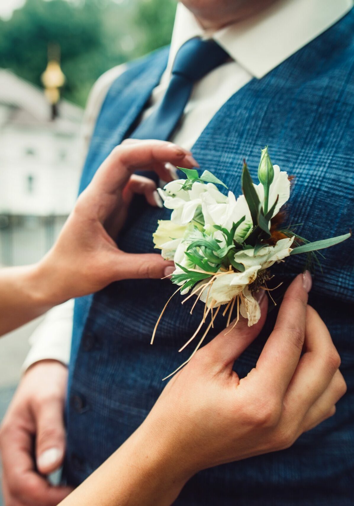 the-bride-s-hands-adjust-the-boutonniere-on-the-gr-2023-11-27-05-29-36-utc